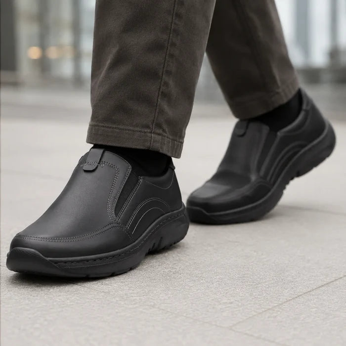 Men's black leather slip-on sneaker with cushioned collar and thick rubber sole