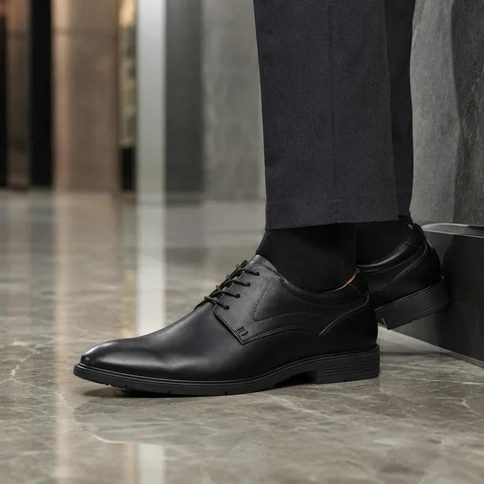 Black leather lace-up business shoes, side view on foot