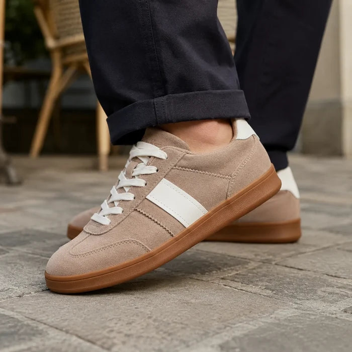 Light brown suede lace-up sneakers with white stripe and gum rubber sole, close-up