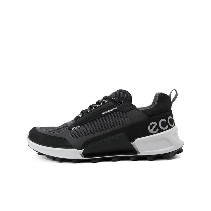 Black lace-up trainers with side logo, strap detail, and white midsole with tread