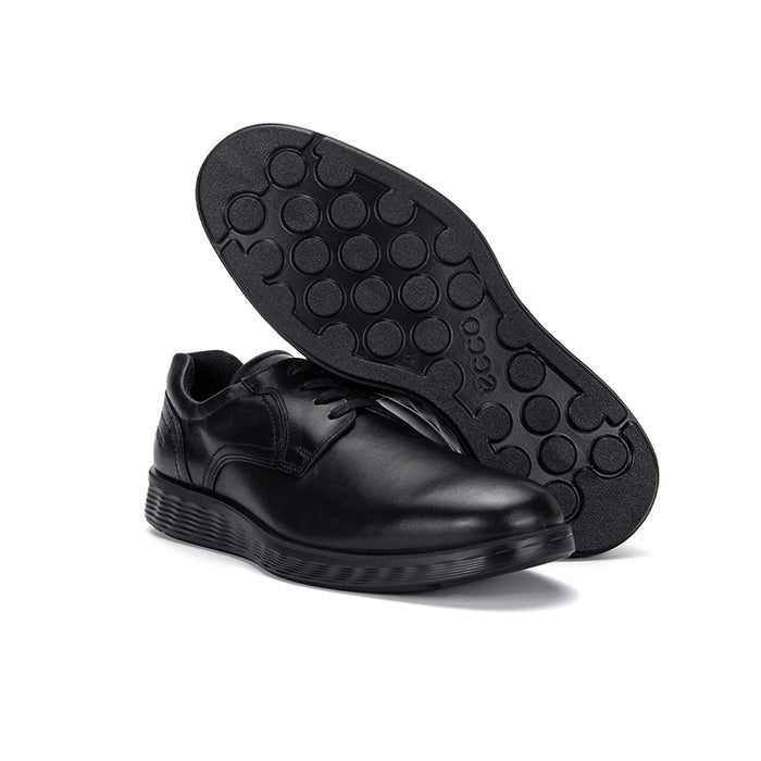 Black rubber outsole with circular tread pattern under derby shoe