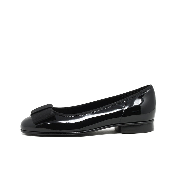 Glossy black leather ballet flat with bow strap and low heel.