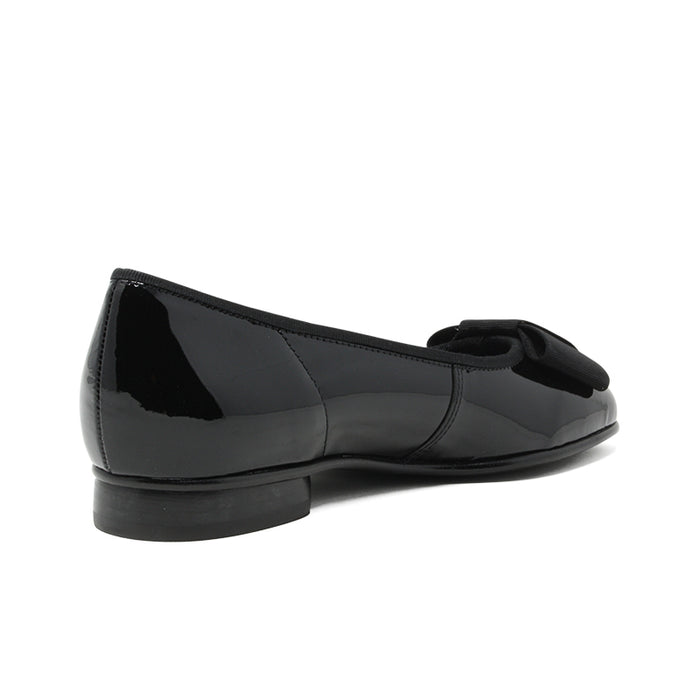 Black leather ballet flat with bow strap and low-profile heel, side view.