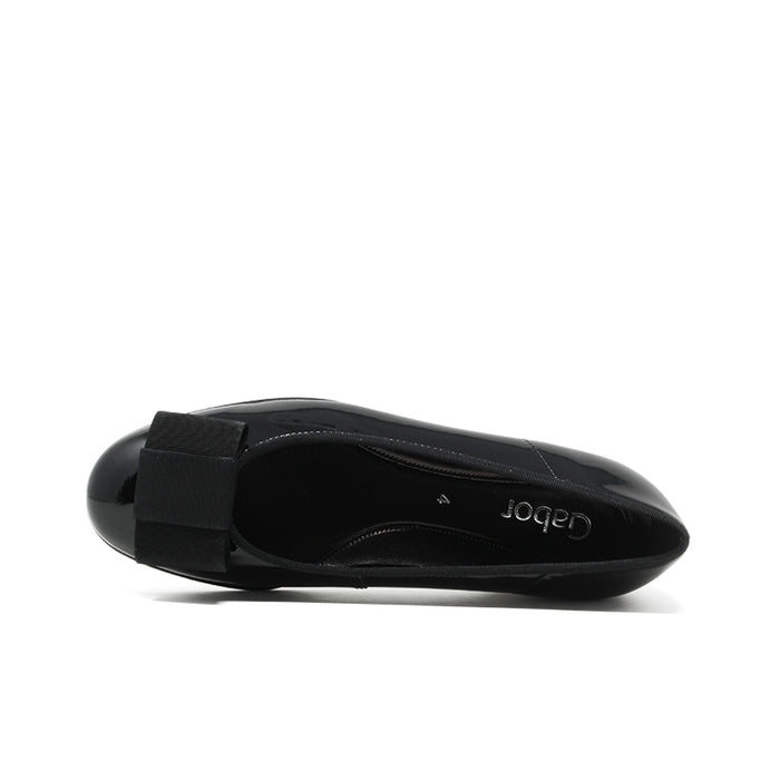 Black leather ballet flat with bow strap and low heel, back view.