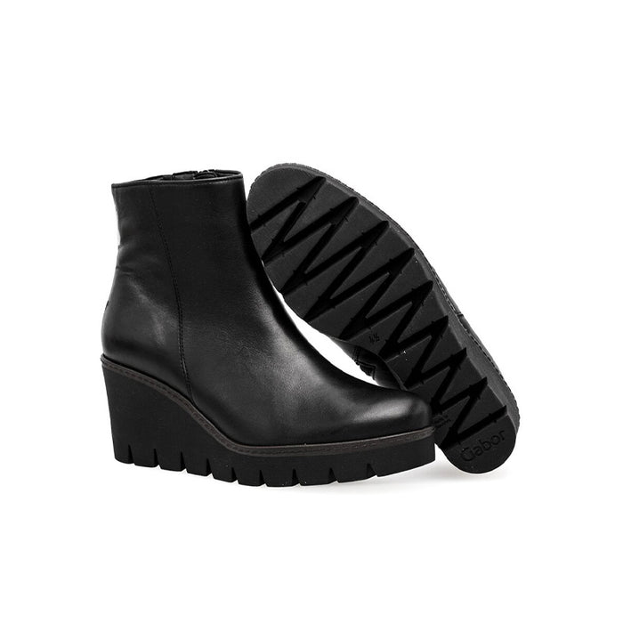 Black leather mid-calf boot with treaded sole underside shown