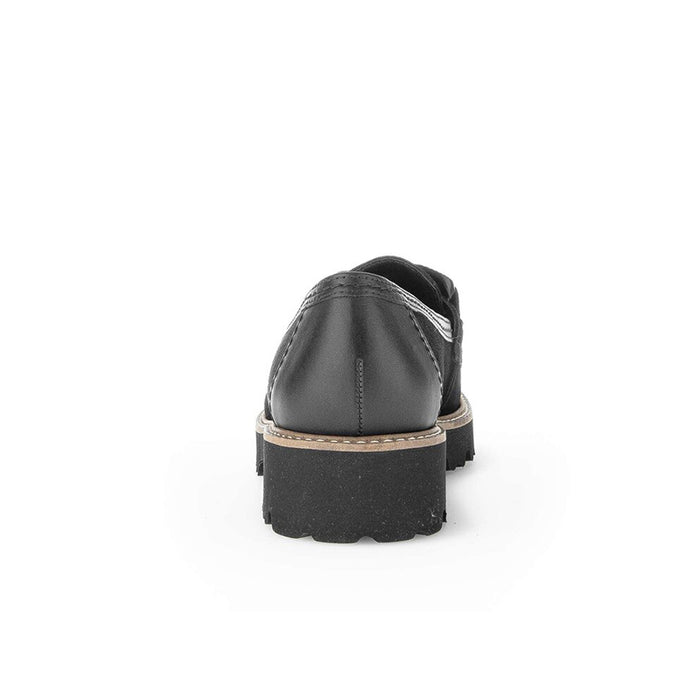 Black loafer heel view with chunky sole and tan welt trim.