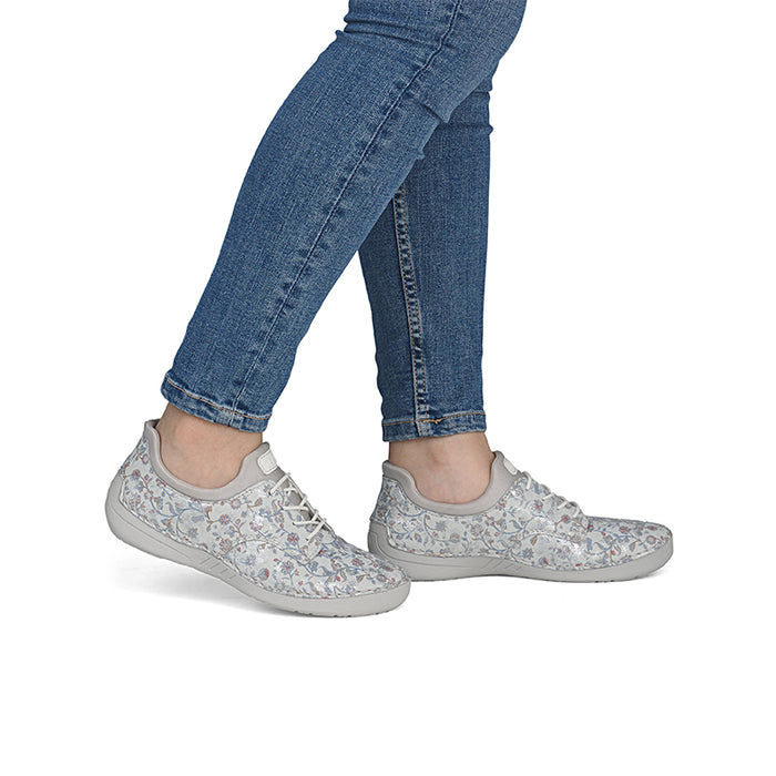Women's Rieker casual sneakers with light gray floral print, lace-up, worn with jeans