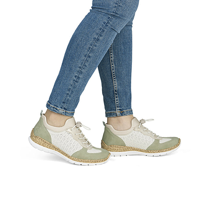 Women’s sneakers on feet with jeans, olive side panels and white knit upper